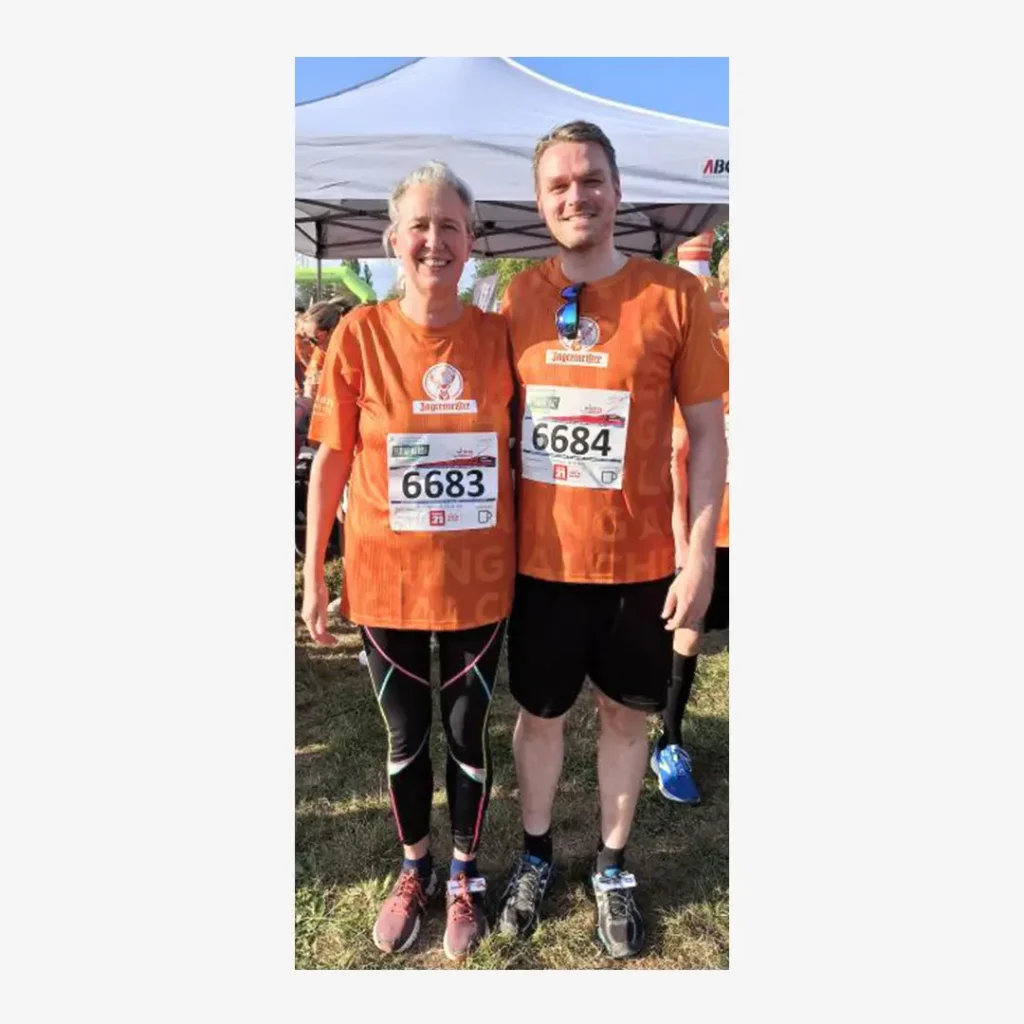 Läufer und Läuferin in organgefarbenen Shirts und den Startnummern 6683 und 6684